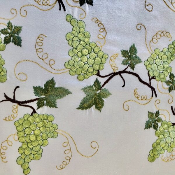 Guilande de raisins verts blancs brodés sur une nappe blanche pour un dîner de fête