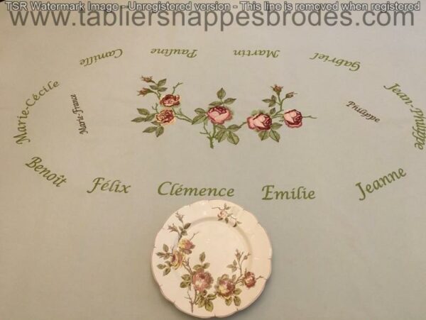 Table élégamment dressée avec nappe brodée à l'identique de la composition florale peinte sur l'assiette en porcelaine ancienne.