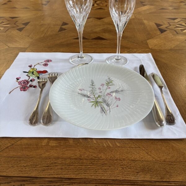 Le motif finement brodé représente deux oiseaux posés sur une branche de fleurs de cerisiers en pleine floraison.Cette scène poétique évoque la nature et la douceur du printemps, apportant à votre table une atmosphère raffinée et harmonieuse.