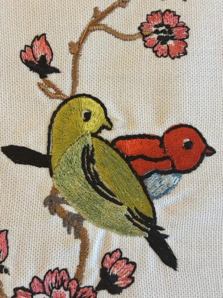 Deux petits oiseaux brodés sur des sets de table en lin