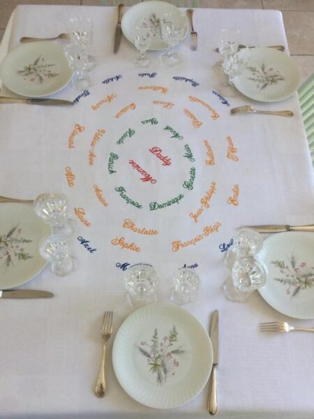 Quatre générations brodés sur une nappe blanche.