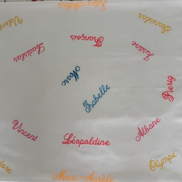 Une nappe famimiale personnalisée réunissant trois générations autour des prénoms brodés.