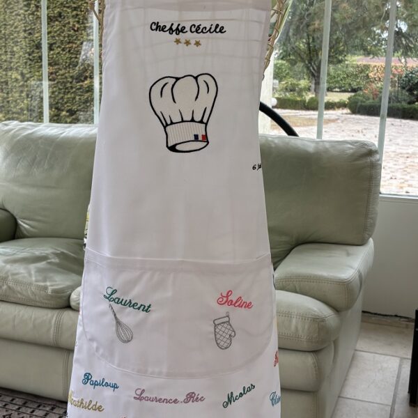 Le tablier de la cheffe Cécile, brodé des prénoms des quarante invités ayant participé à cette soirée culinaire.