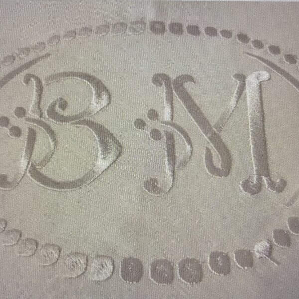 Une nappe blanche personnalisée d'un grand monogramme brodé en son centre